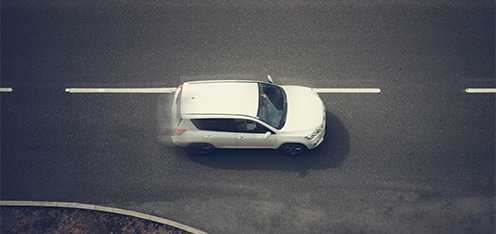 Carro blanco a gran velocidad sobre una vía.