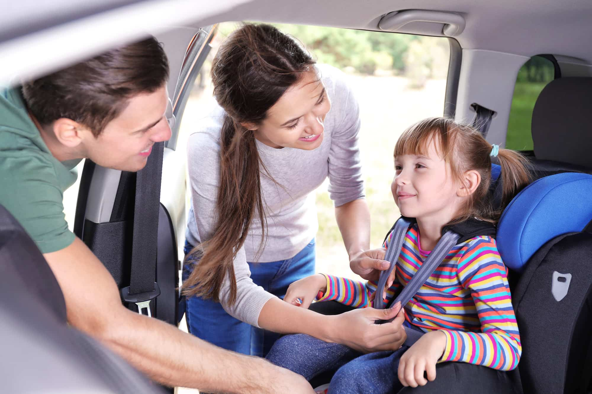 Padres aseguran silla de vehiculo para su hija